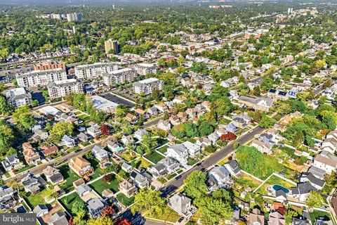 an aerial view of residential houses with outdoor space and trees