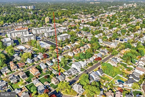 an aerial view of residential houses with outdoor space and trees