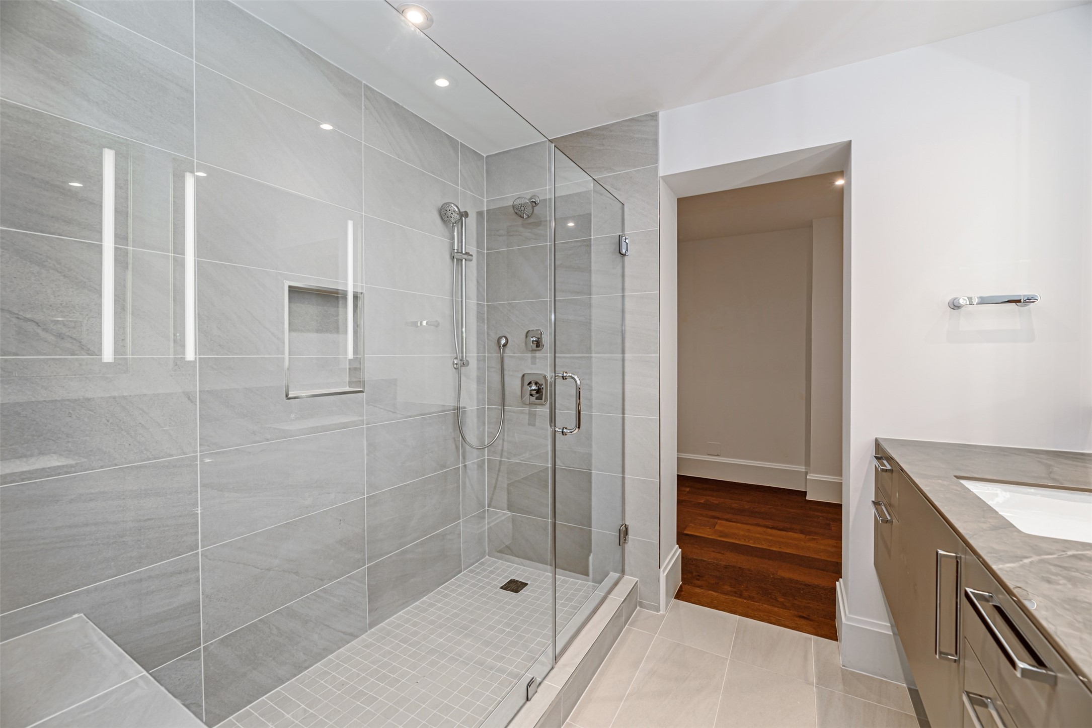 1701 Hermann Drive, Unit 34L Houston, TX 77004 - Photo 14 of 37 The serene primary bathroom with oversized European frameless shower and floating double vanity flows right into the walk-in closet.