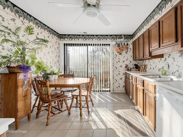 a kitchen with stainless steel appliances a table and chairs in it