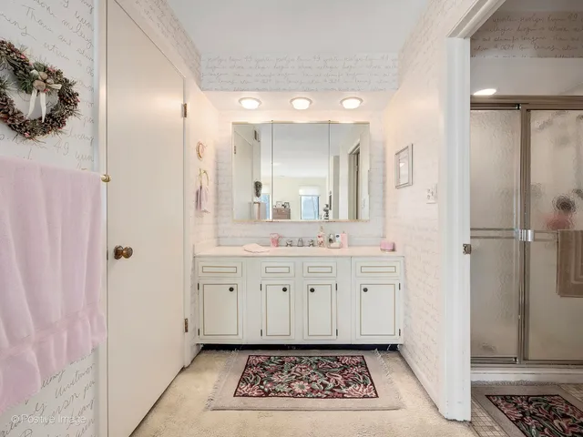 a bathroom with a sink mirror and a shower