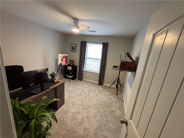 a view of a workspace with furniture and a window