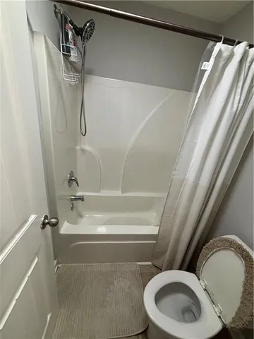 a bathroom with a toilet and a shower