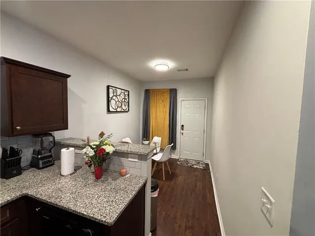 a view of a kitchen area with furniture and wooden floor
