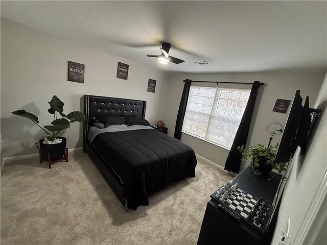 a bedroom with a bed potted plant with the mirror
