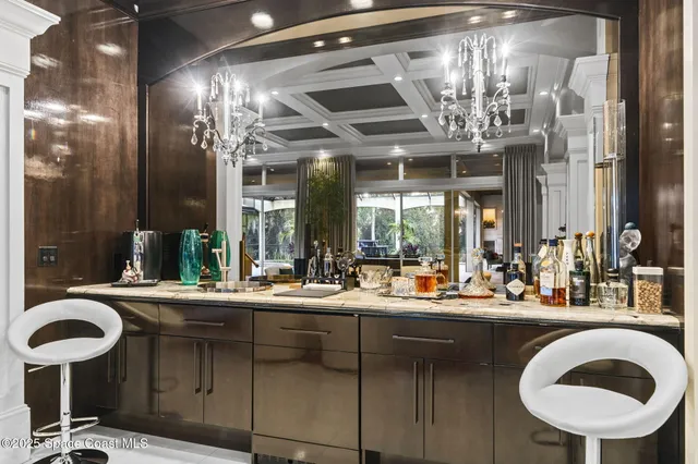 a living room with furniture a large window and a chandelier