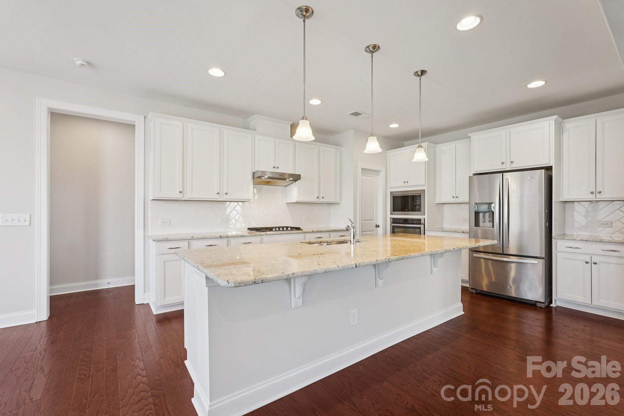 17422 Shearer Road Davidson, NC 28036 - Photo 2 of 48 a large kitchen with stainless steel appliances kitchen island granite countertop a refrigerator a oven a sink and white cabinets with wooden floor