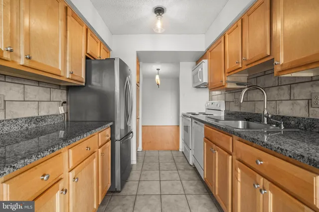 a kitchen with stainless steel appliances granite countertop a sink and cabinets
