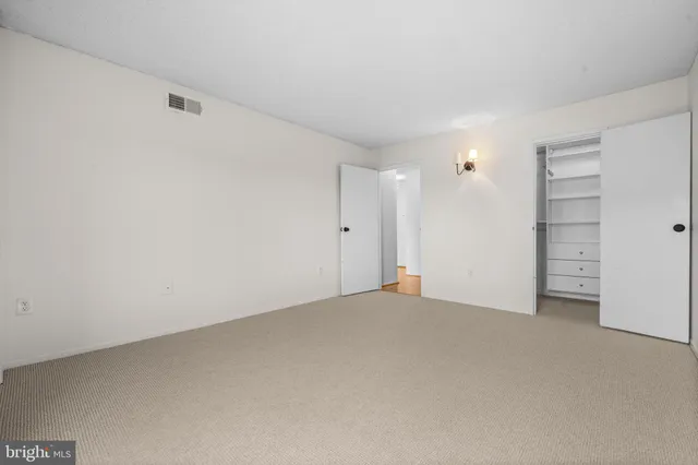 a view of an empty room and closet area