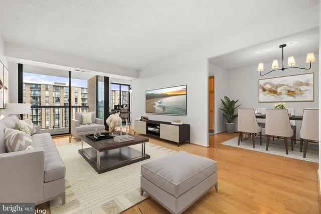 a living room with furniture flat screen tv and a large window