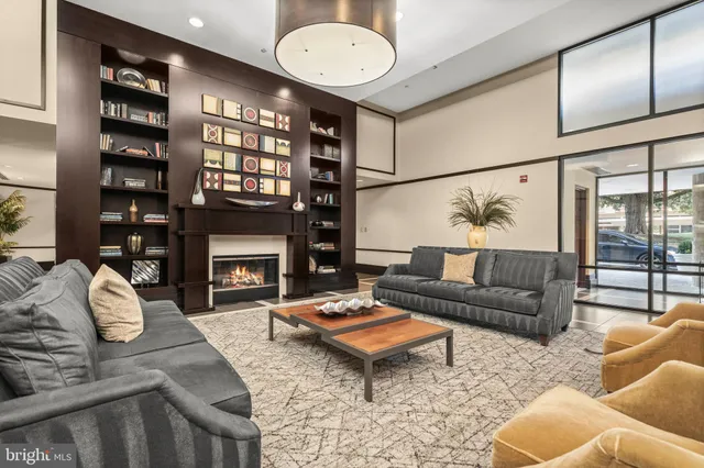 a living room with furniture a fireplace and a large window