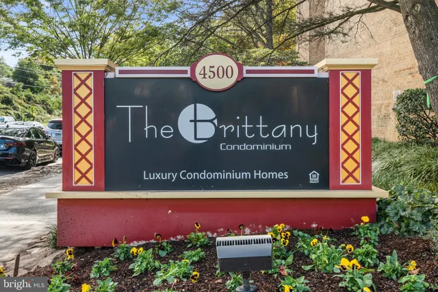 a street sign on a wall next to a road