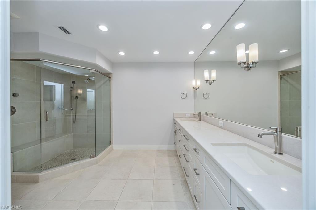 121 Bears Paw Trail Naples, FL 34105 - Photo 15 of 39 a bathroom with a double vanity sink a large mirror and shower