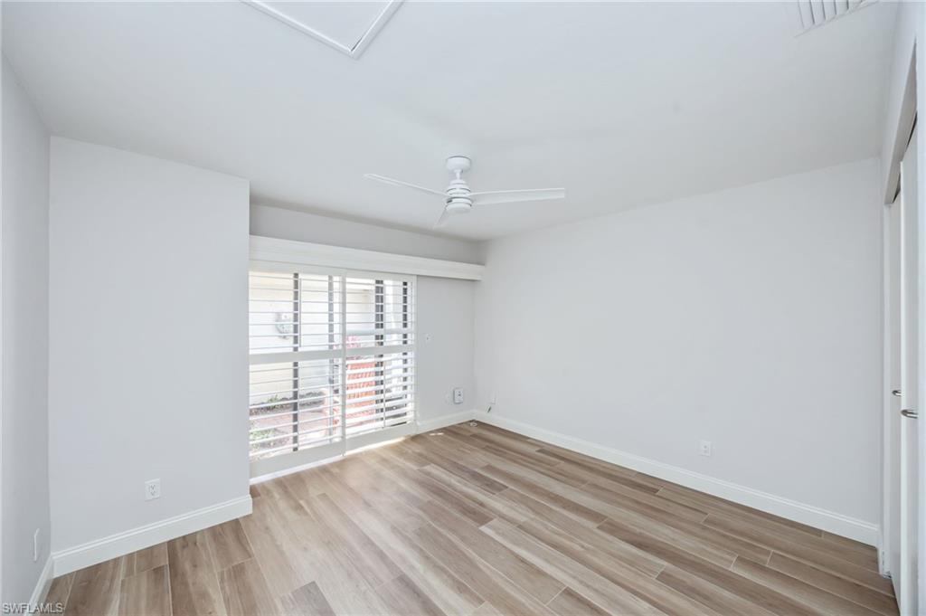 121 Bears Paw Trail Naples, FL 34105 - Photo 17 of 39 an empty room with wooden floor and windows