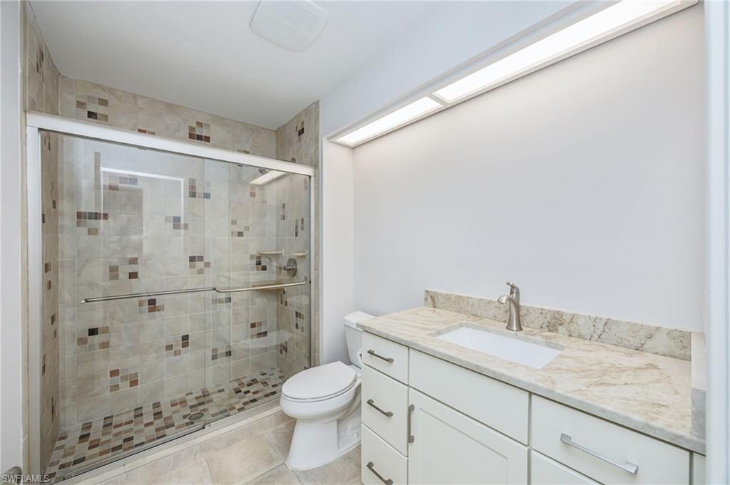121 Bears Paw Trail Naples, FL 34105 - Photo 19 of 39 a bathroom with a granite countertop sink a toilet and shower