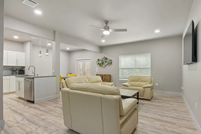 a living room with furniture a flat screen tv and a window