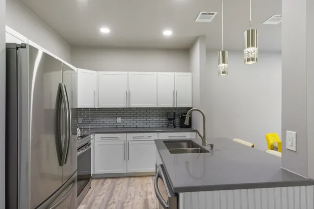 a kitchen with stainless steel appliances granite countertop a sink a stove counter space and cabinets