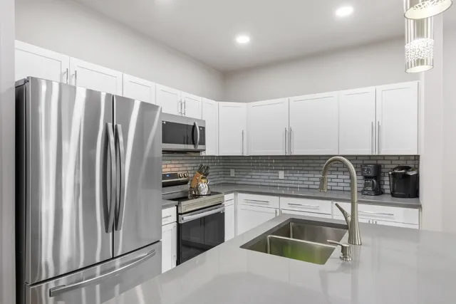 a kitchen with stainless steel appliances granite countertop a sink stove and refrigerator