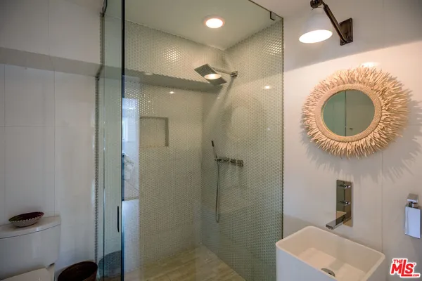 a bathroom with a mirror a sink and a shower