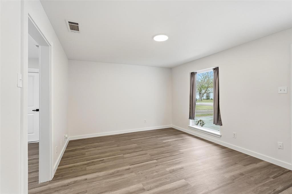 513 Paddy Street Mesquite, TX 75149 - Photo 3 of 18 an empty room with wooden floor and windows