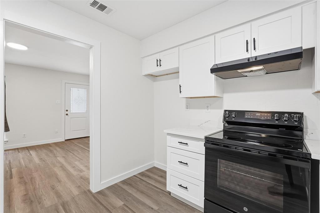 513 Paddy Street Mesquite, TX 75149 - Photo 10 of 18 a kitchen with wooden cabinets and a stove top oven