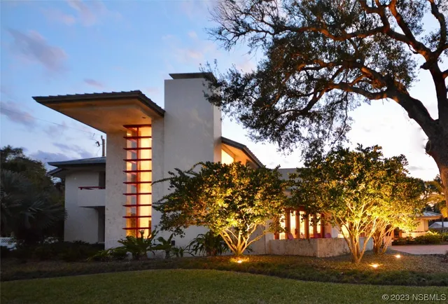 a yellow house with trees in front of it