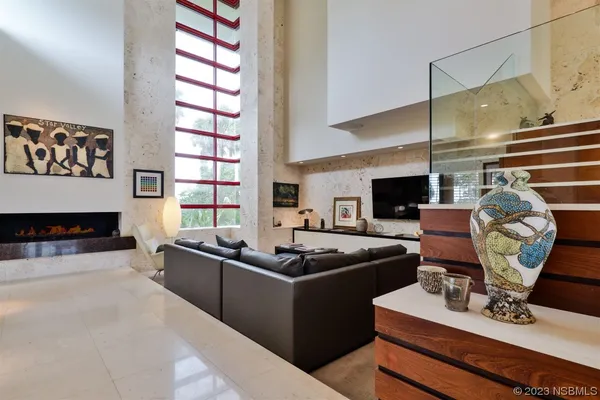 a living room with fireplace furniture and floor to ceiling window