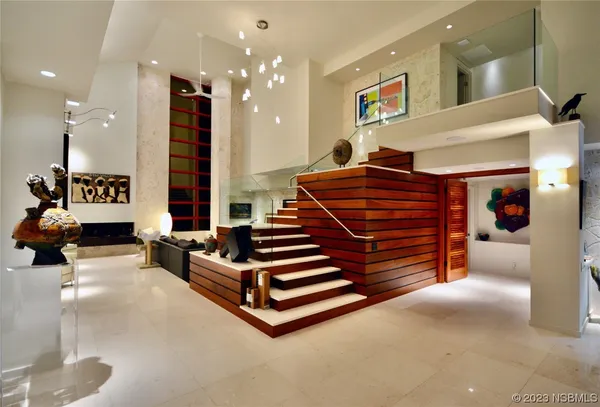 a living room with stainless steel appliances furniture a rug and a kitchen view