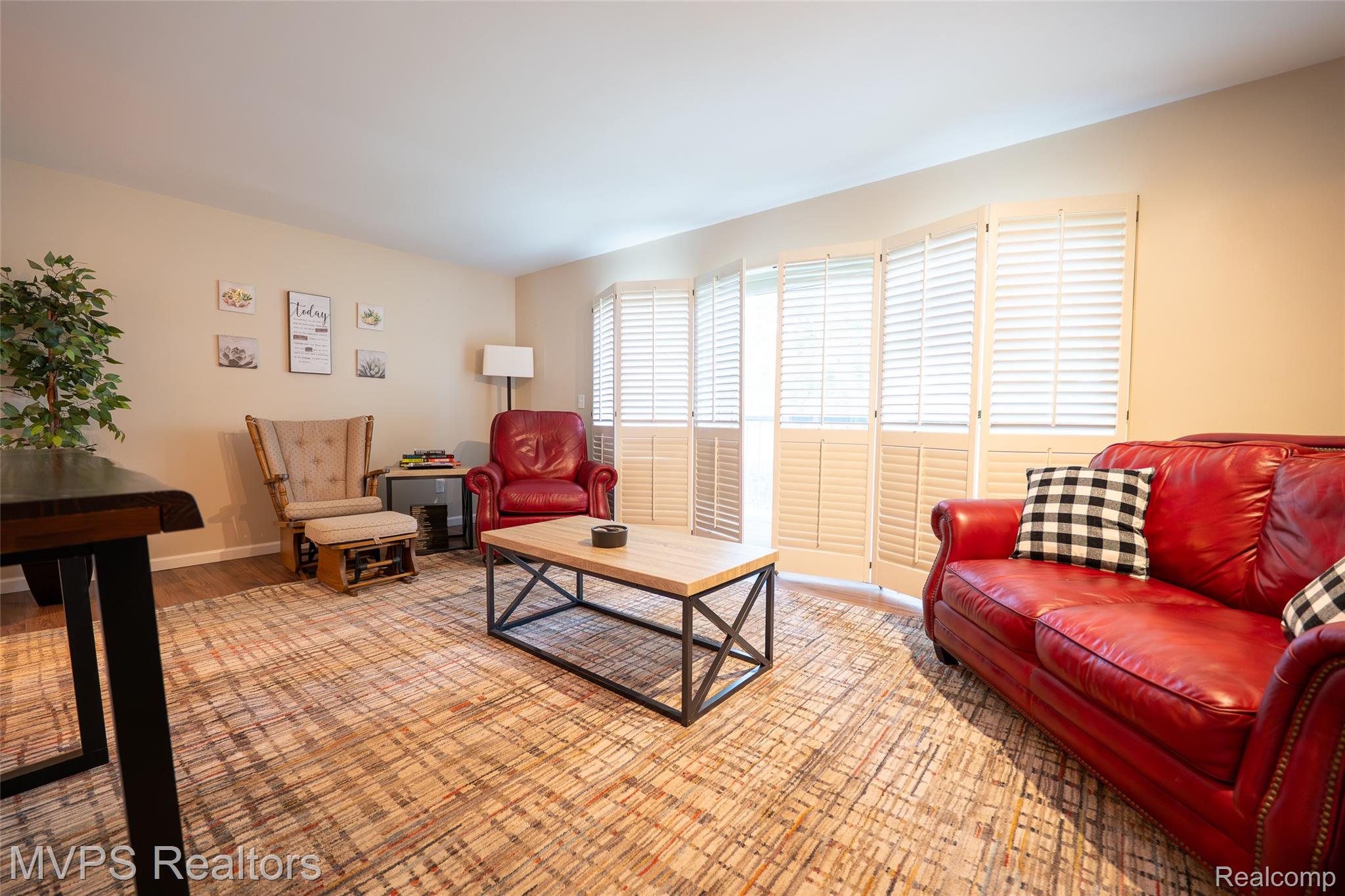 804 Oak Brook Ridge Drive, Unit 149 Rochester, MI 48307 - Photo 11 of 49 Living area featuring wood-finish flooring, neutral wall tones, and white plantation shutters spanning multiple windows