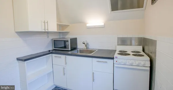 a kitchen with white cabinets and white appliances