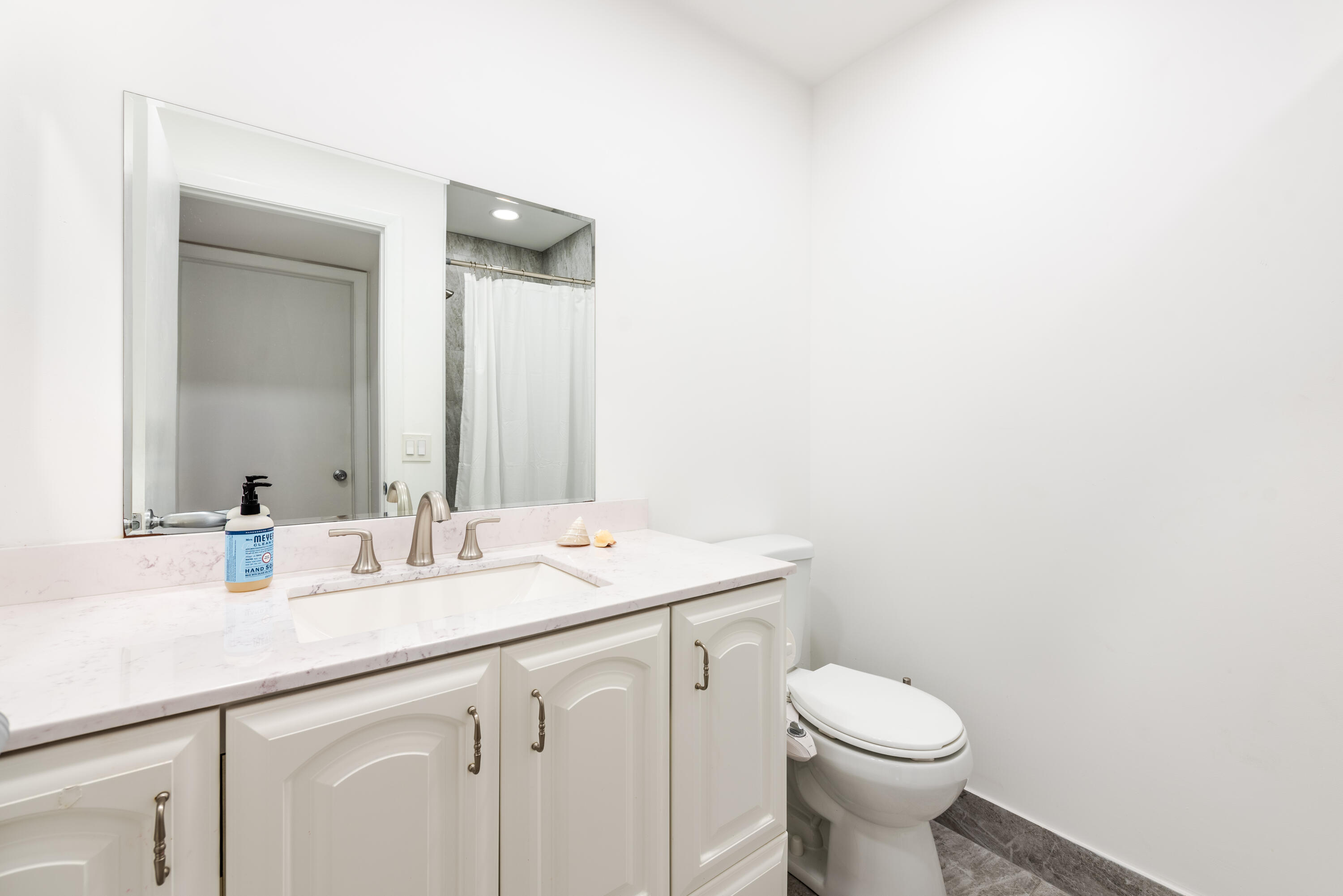 369 Capri H Delray Beach, FL 33484 - Photo 15 of 37 a bathroom with a sink a toilet and mirror