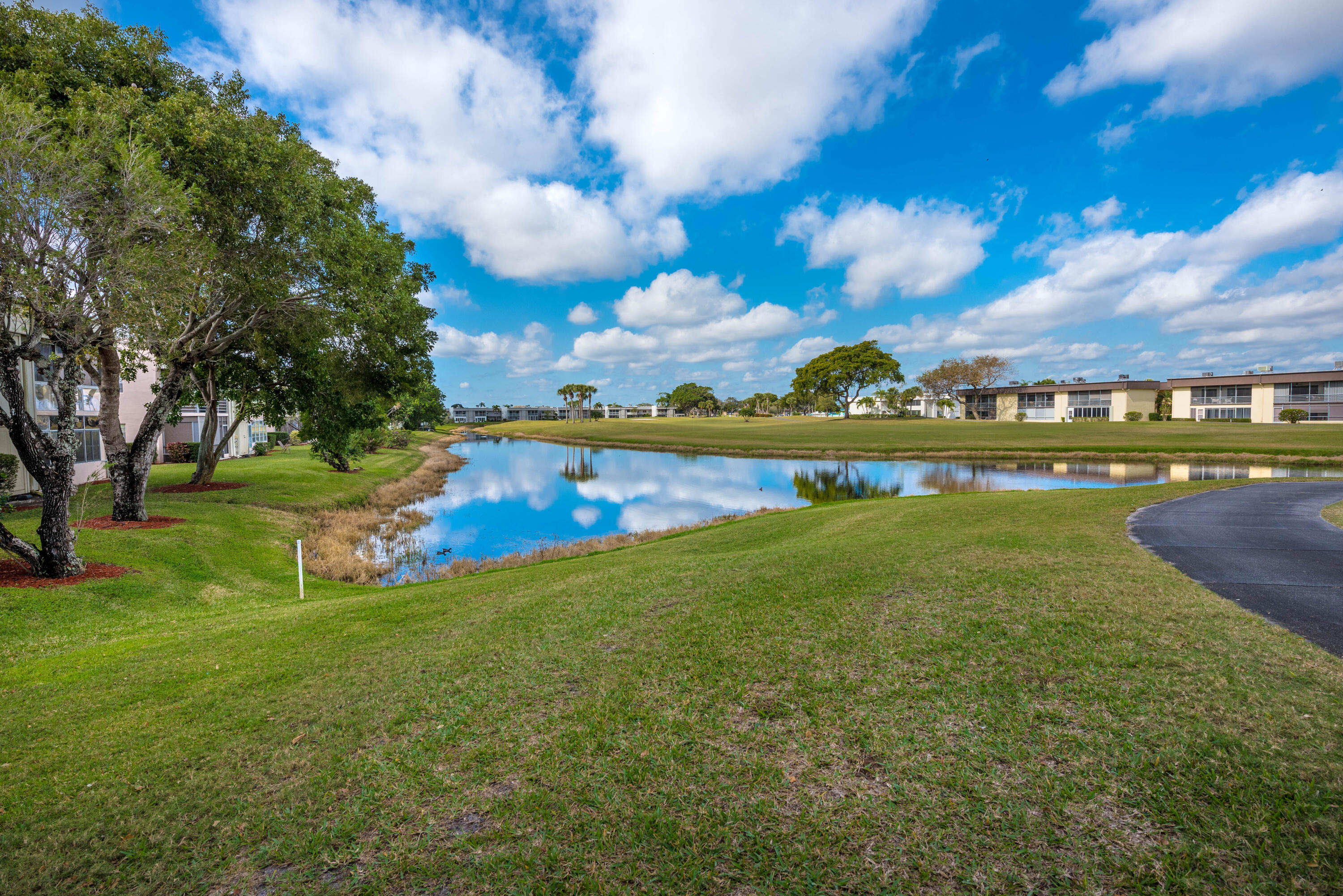 369 Capri H Delray Beach, FL 33484 - Photo 27 of 37 a view of a lake with houses in the back