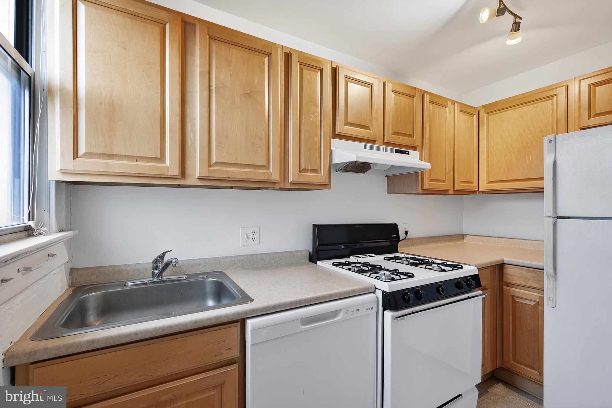 1820 Clydesdale Place Northwest, Unit 411 Washington, DC 20009 - Photo 11 of 33 a kitchen with stainless steel appliances granite countertop a sink stove and cabinets
