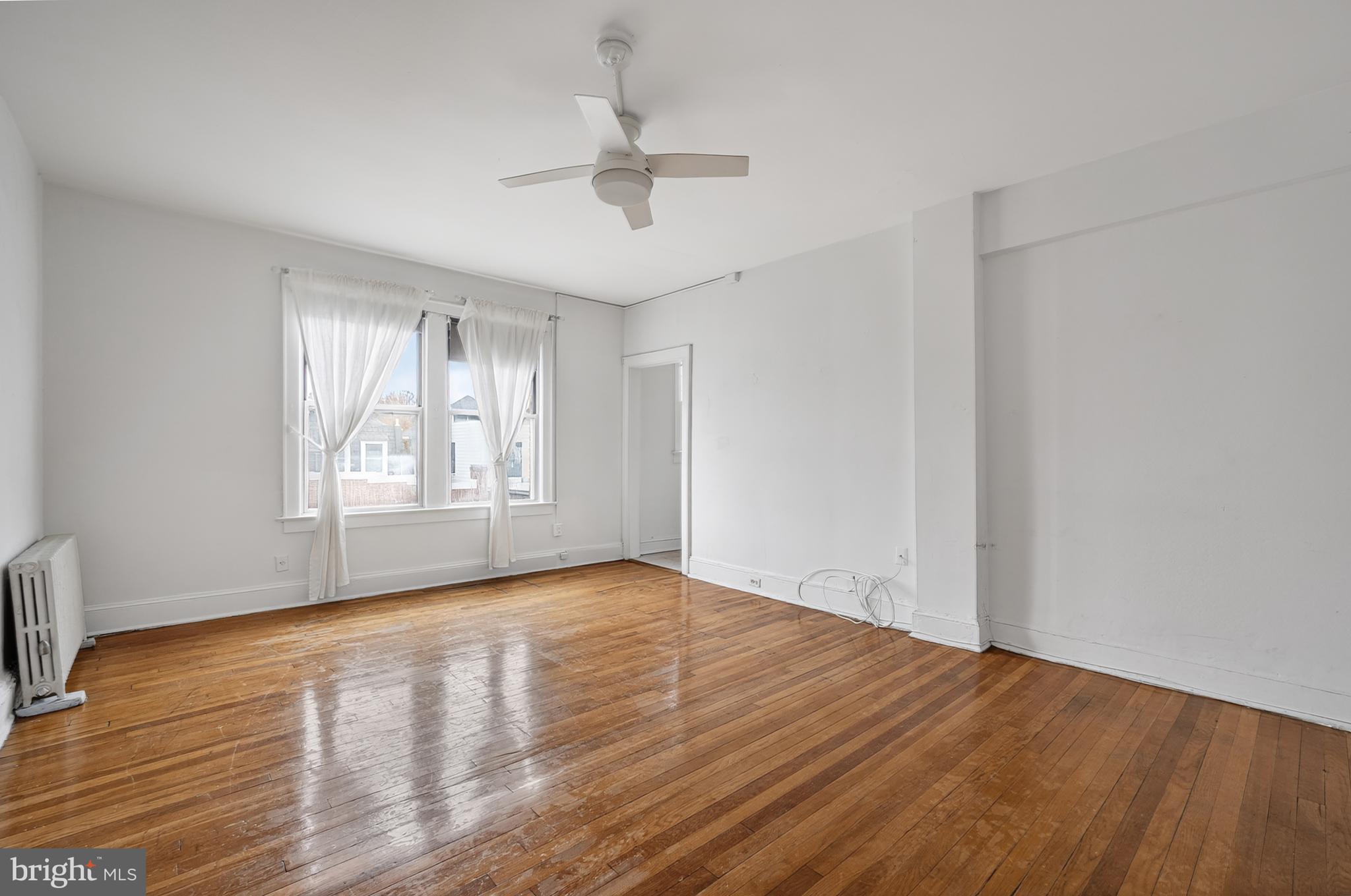 1820 Clydesdale Place Northwest, Unit 411 Washington, DC 20009 - Photo 8 of 33 an empty room with wooden floor chandelier fan and windows