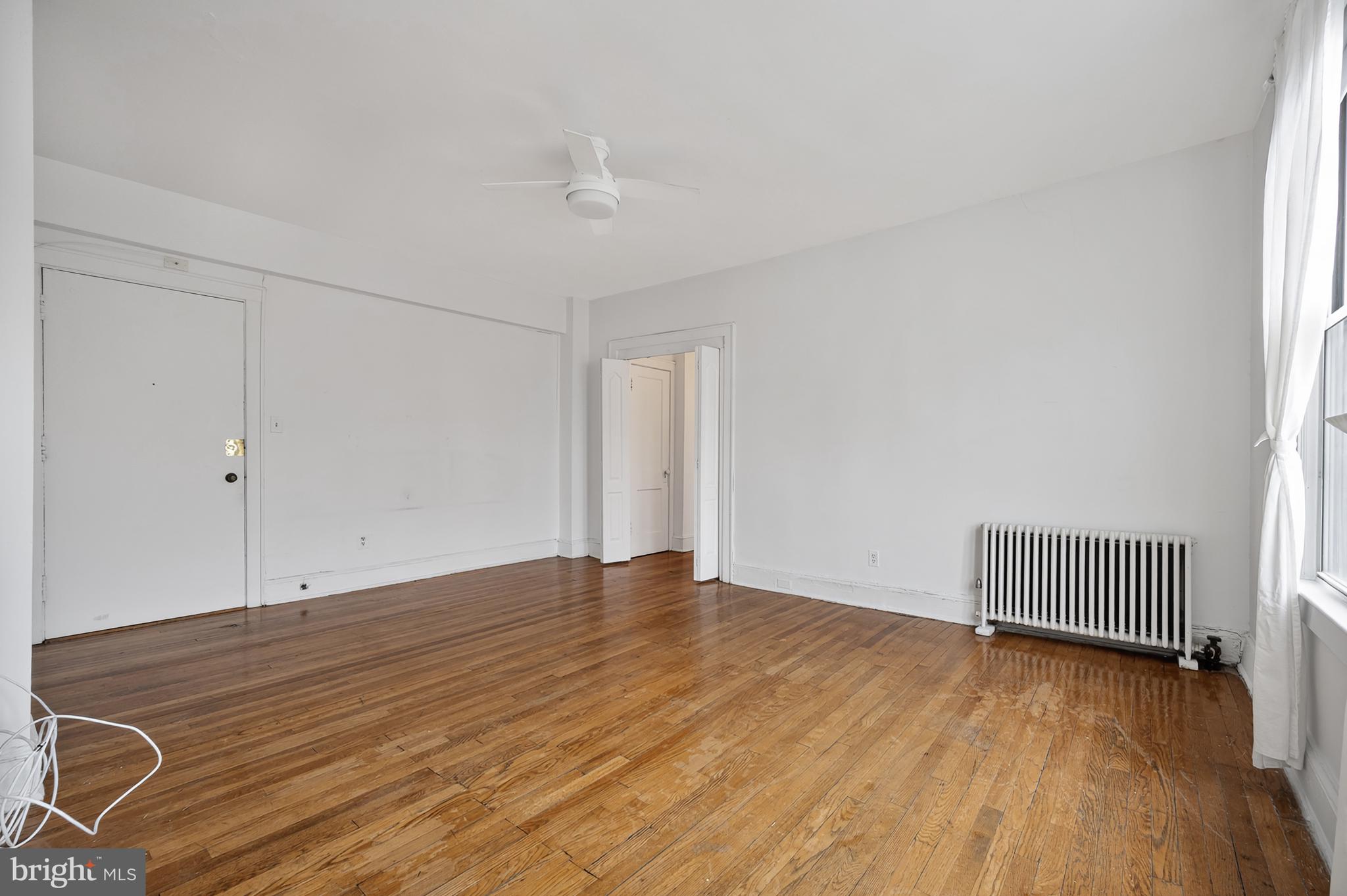 1820 Clydesdale Place Northwest, Unit 411 Washington, DC 20009 - Photo 9 of 33 an empty room with wooden floor and windows