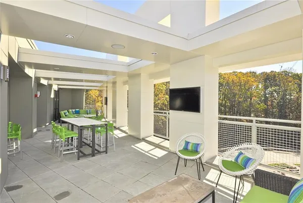 a living room with furniture a flat screen tv and a large window