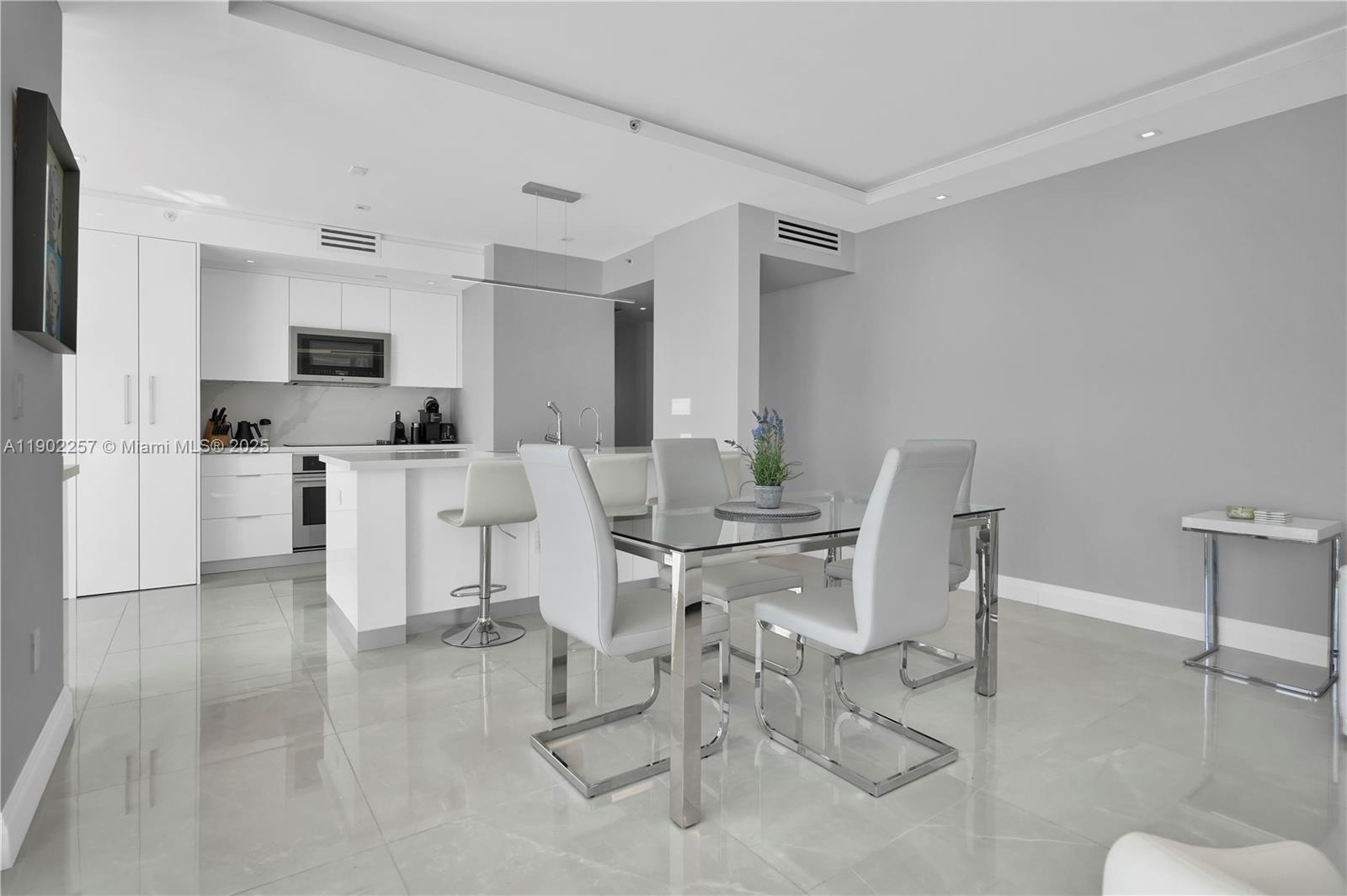 4201 Collins Avenue, Unit 2101 Miami Beach, FL 33140 - Photo 11 of 50 a living room with furniture a flat screen tv and kitchen view