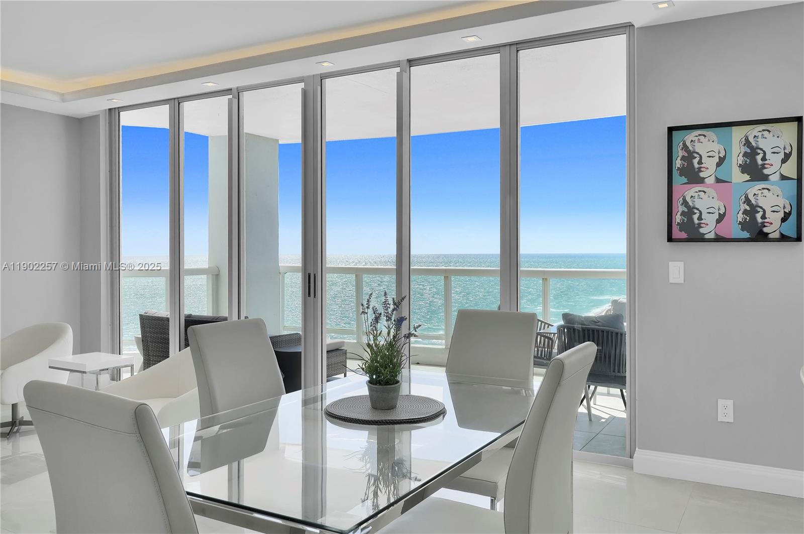 4201 Collins Avenue, Unit 2101 Miami Beach, FL 33140 - Photo 15 of 50 a view of a dining room with furniture large windows and wooden floor