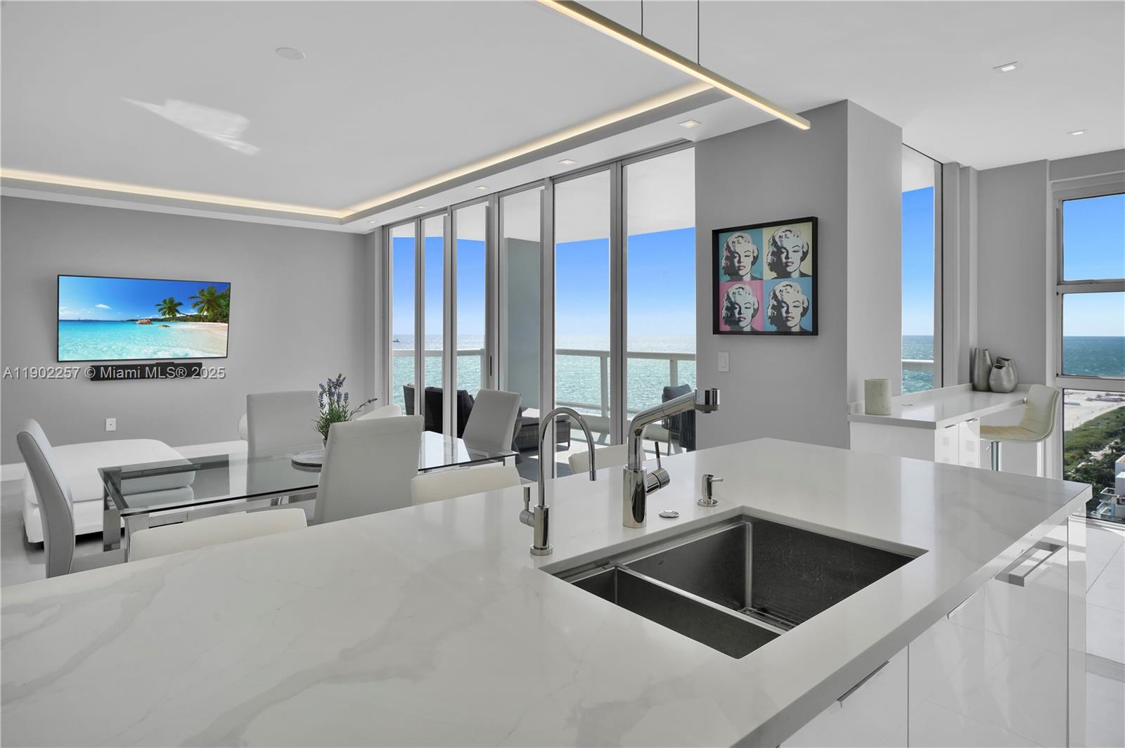 4201 Collins Avenue, Unit 2101 Miami Beach, FL 33140 - Photo 3 of 50 a kitchen with a white cabinets and chairs