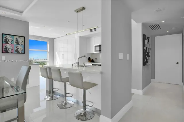 a living room with furniture a flat screen tv and kitchen view