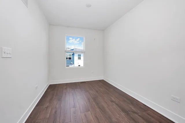 a view of a small space with wooden floor and a window
