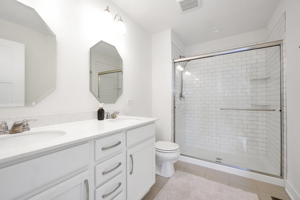 4133 Calder Lane Aurora, IL 60504 - Photo 19 of 38 a bathroom with a double vanity sink toilet and shower