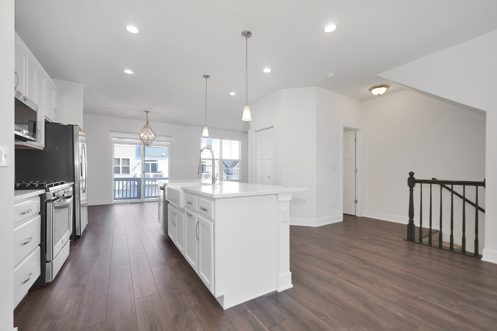 4133 Calder Lane Aurora, IL 60504 - Photo 7 of 38 a large kitchen with kitchen island a island in the center and wooden floor