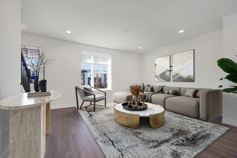 a living room with furniture a flat screen tv and a table
