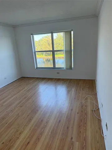 a view of a room with wooden floor and white walls