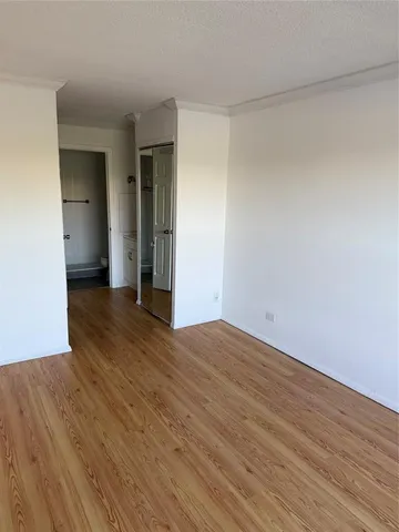 an empty room with wooden floor and mirror