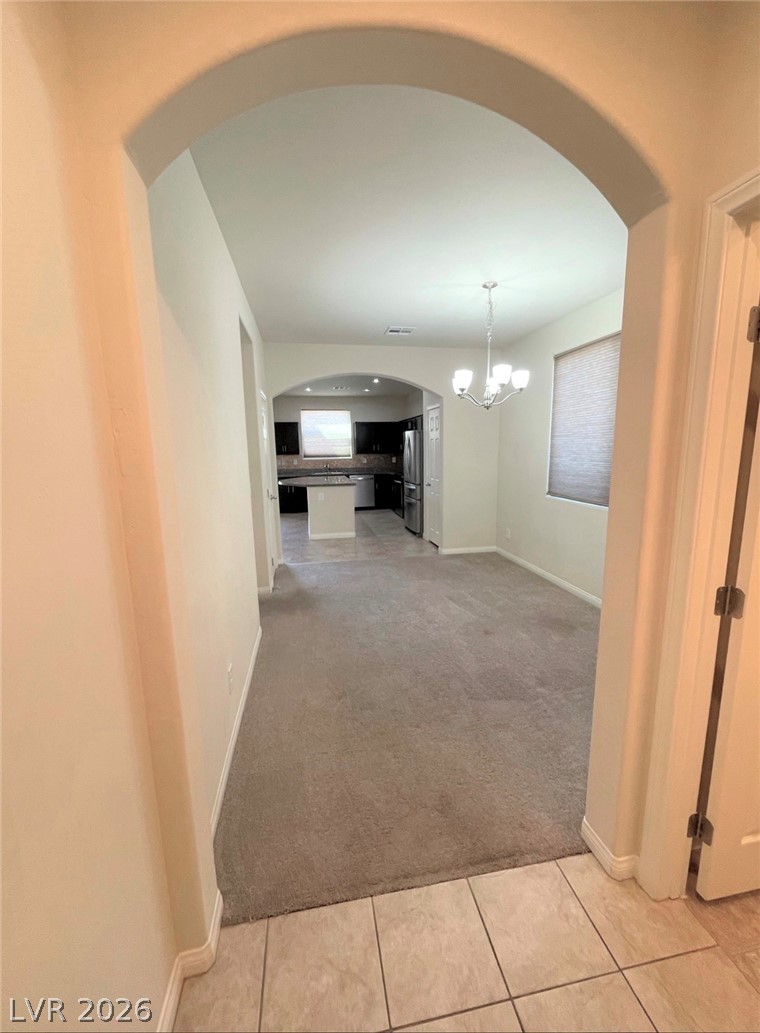 7063 Claythorn Road Las Vegas, NV 89148 - Photo 5 of 30 An inviting view leads through an archway to a well-lit living area and kitchen beyond.