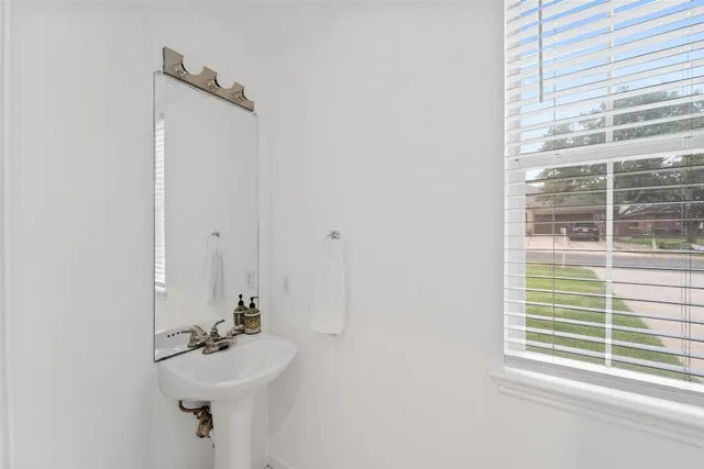 a bathroom with a sink a mirror and a window