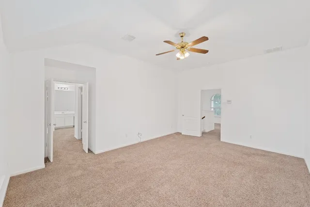 a view of a room with a ceiling fan and window