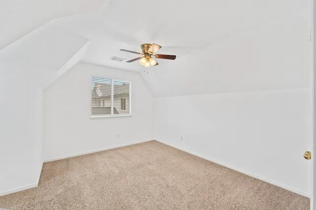 an empty room with a window and a ceiling fan